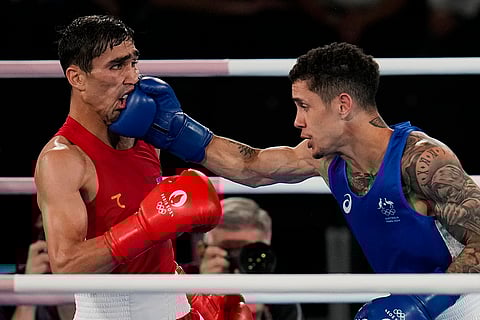 Uzbekistan's Abdumalik Khalokov, left, fights Australia's Charlie Senior in Men's 57 kg semifinal boxing